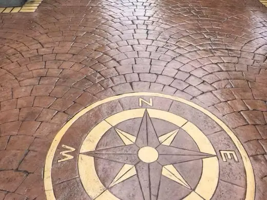 Compass rose inlay in a contrasting colour on stamped concrete, photo 1