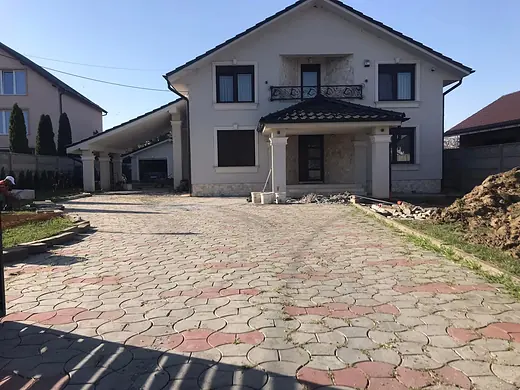 Alter rot-grauer Verbundsteinbelag vor einem Wohnhaus