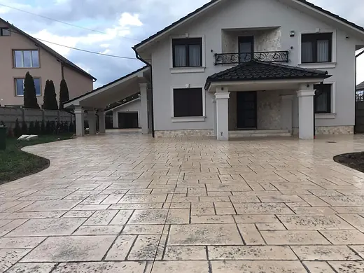 Fertiger Hof aus hellem Prägebeton vor dem Wohnhaus