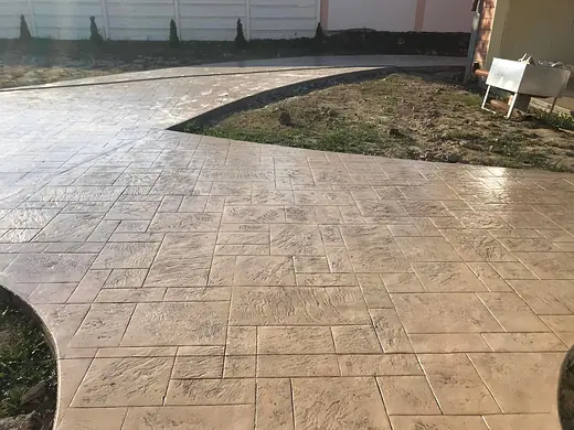 Geschwungene Kante der Betonfläche entlang der Rasenfläche
