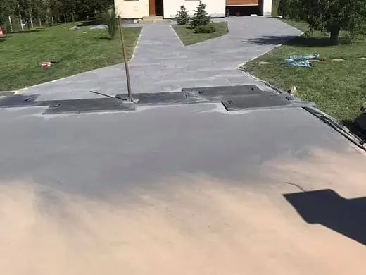 Frisch betonierter Vorplatz, noch grau und ohne Prägung