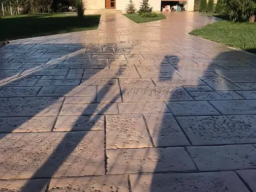 Fertiger Vorplatz aus braunem Prägebeton vor dem Wohnhaus