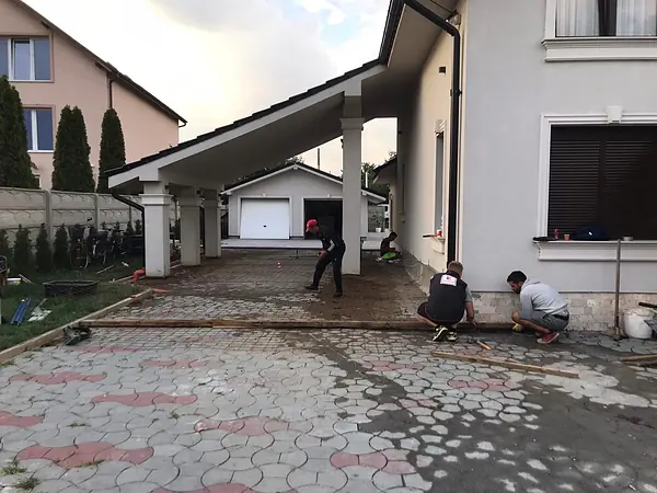 Zwei Mitarbeiter arbeiten die frisch geprägte Betonfläche von Hand nach